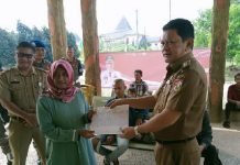Tinjau Pelayanan Disdukcapil, Pj Bupati Turut Melayani Serahkan KK Kepada Warga